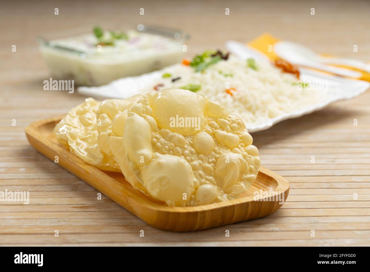 Kerala Papadum o pappadom piano o Appalam, disposti in un tavola di legno come piatto laterale per la verdura biryani su sfondo in legno testurizzato, fuoco selettivo Foto Stock