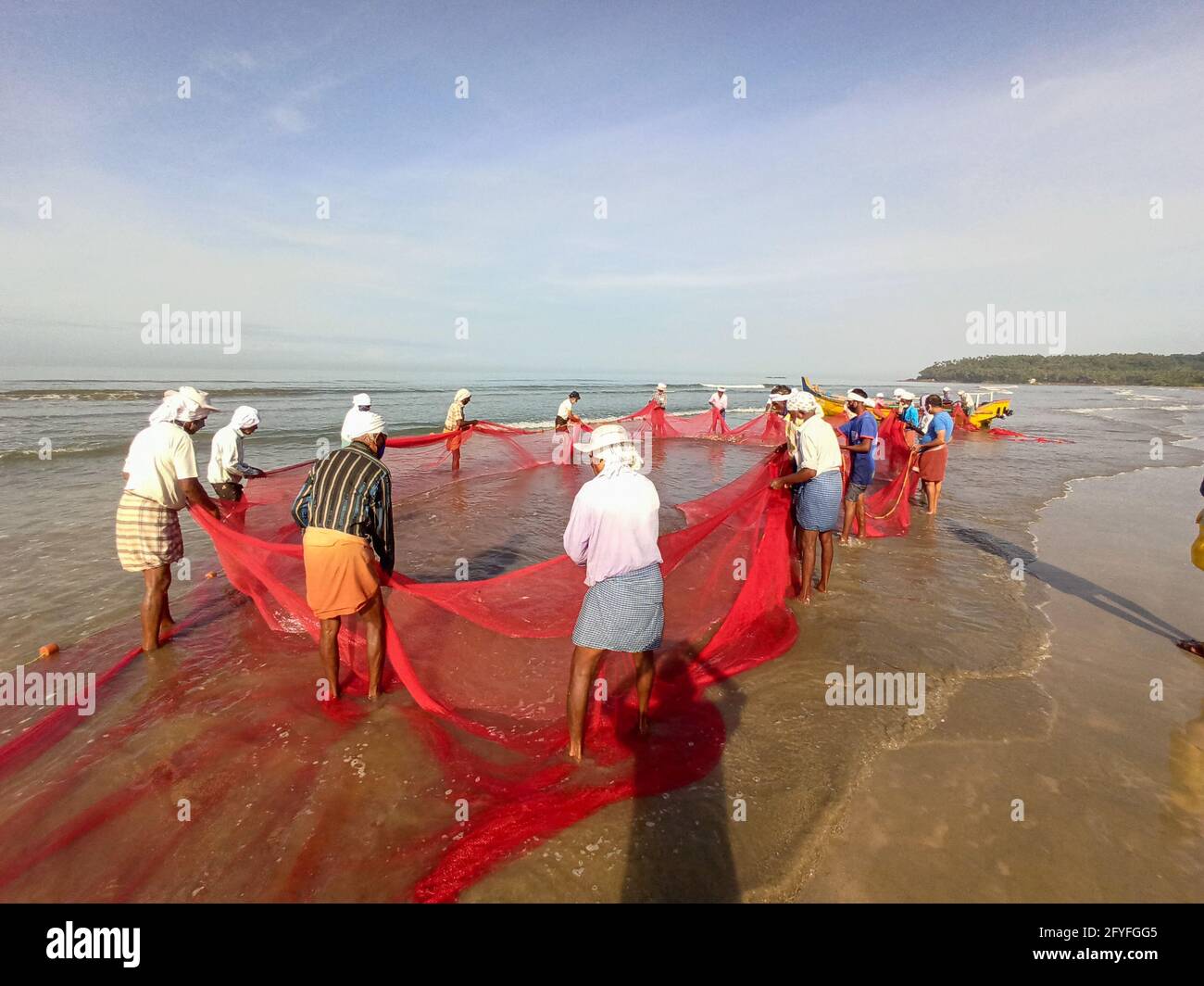 India, Kerala, Kannur-Ottobre 2020: Pescatori a Kannur Drive-in-Beach, alcuni dei pescatori che tirano la rete dal mare per raccogliere pesci, fuoco selettivo. Foto Stock