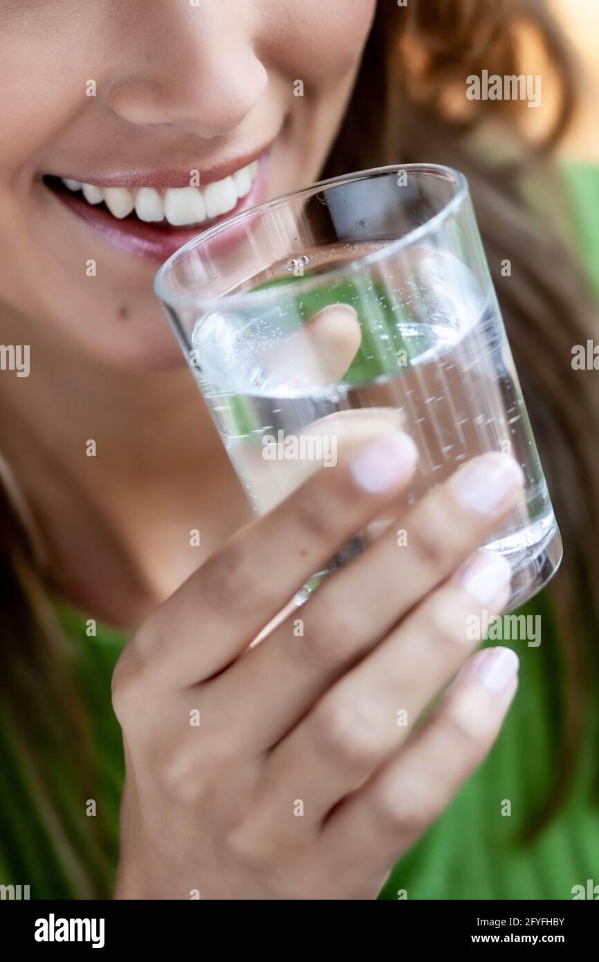 Donna di bere un bicchiere d'acqua. Foto Stock