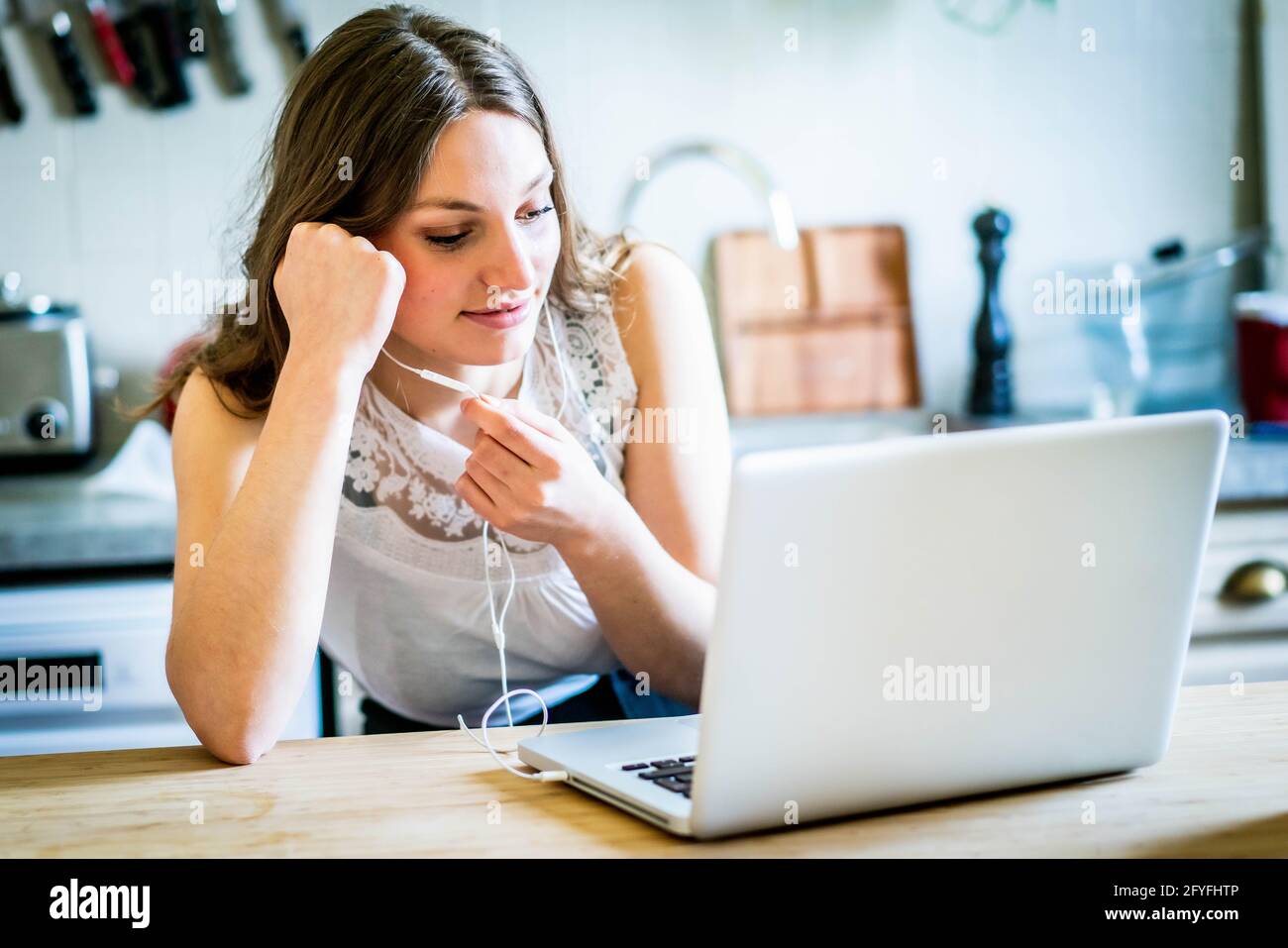 Giovane donna che utilizza un kit vivavoce. Foto Stock