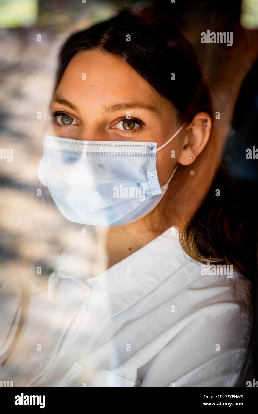 Donna che indossa una maschera chirurgica. Foto Stock