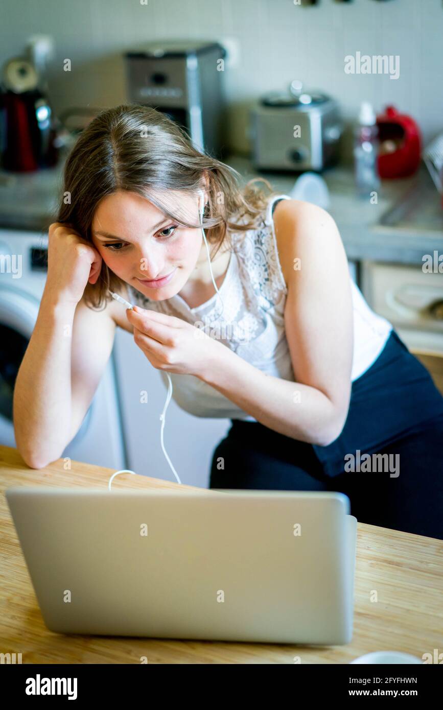 Giovane donna che utilizza un kit vivavoce. Foto Stock