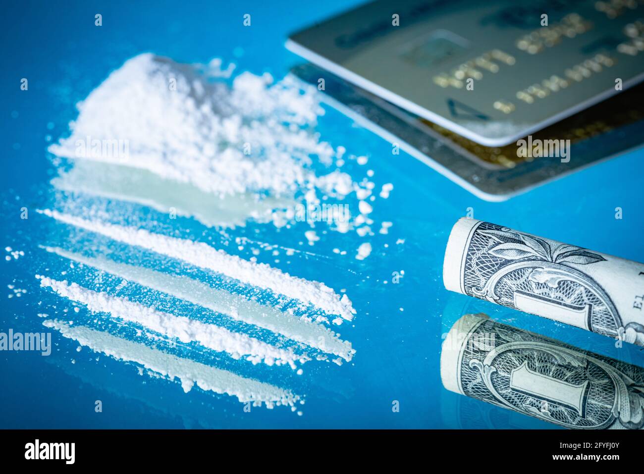 La nota bancaria arrotolata è usata per snort una linea di cocaina. Foto Stock
