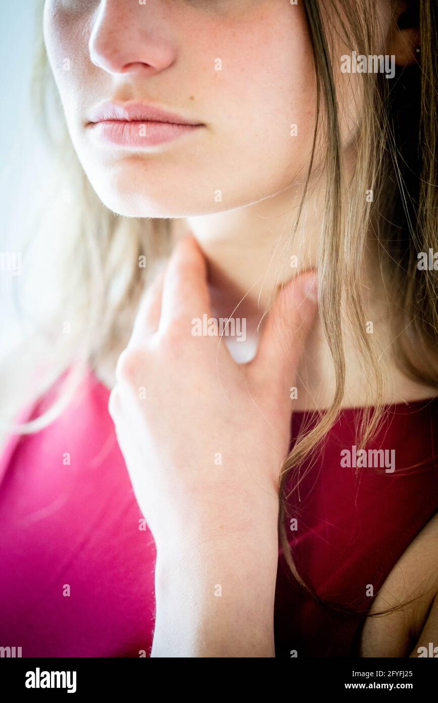 Donna auto-esaminando la sua gola. Foto Stock