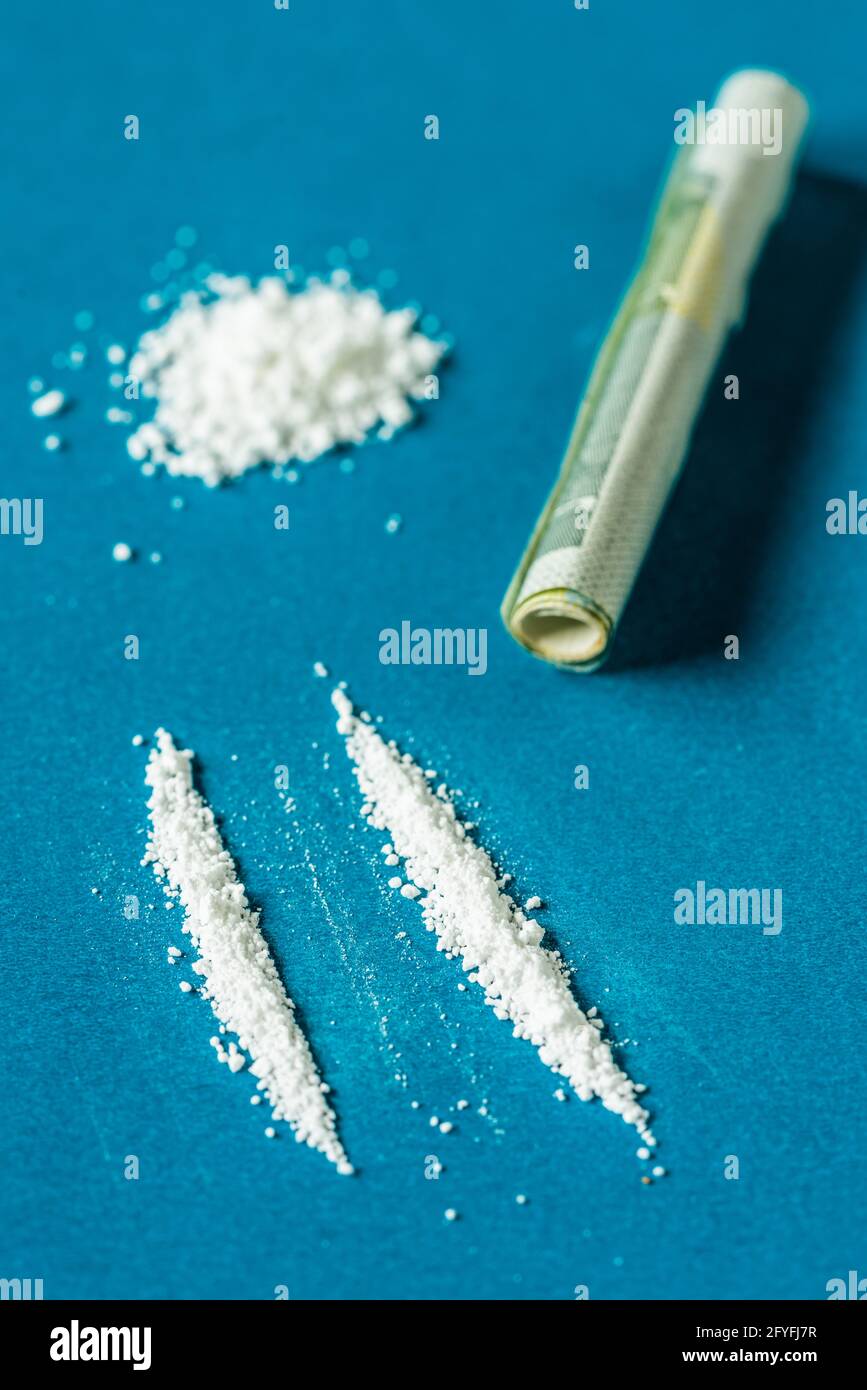 La nota bancaria arrotolata è usata per snort una linea di cocaina. Foto Stock