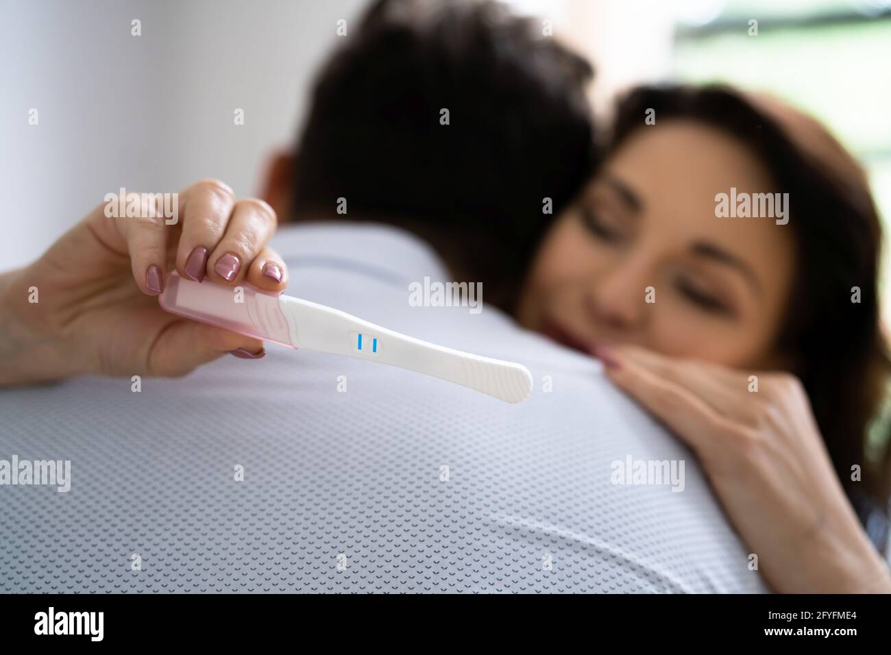 Felice coppia con il test di gravidanza. I genitori sono molto contenti Foto Stock