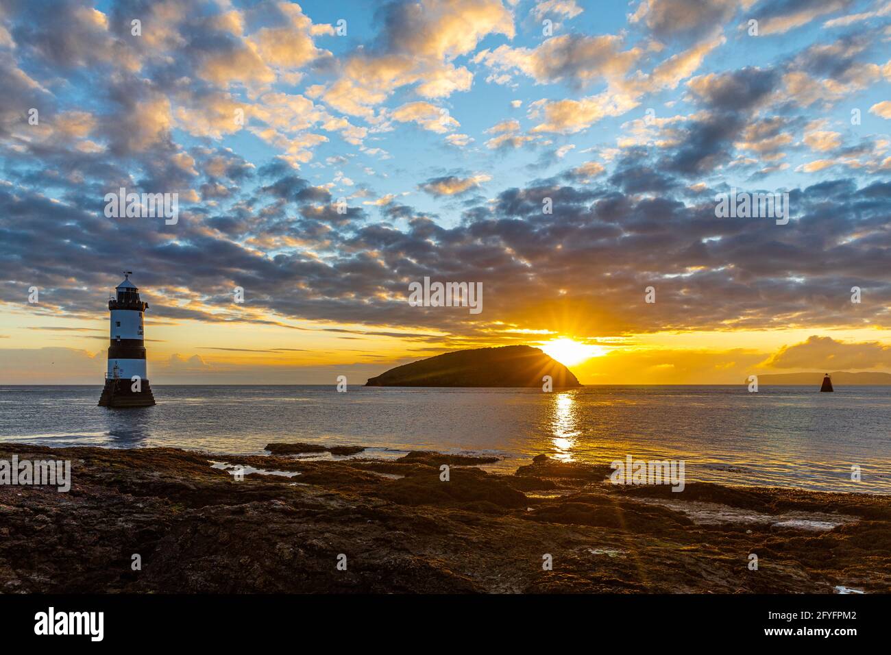 Faro di Penmon, Trwyn Du, Isola di Puffin all'alba da Penmon Point, Anglesey, Galles. Foto Stock