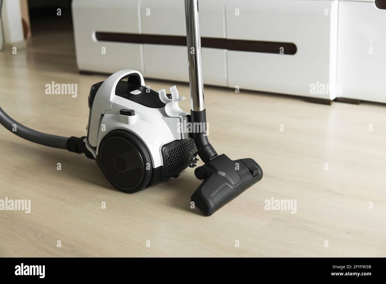 Aspirapolvere ciclone senza sacco su un laminato. Apparecchi elettrici che, mediante aspirazione, raccolgono polvere e piccole particelle dai pavimenti e da altri Foto Stock