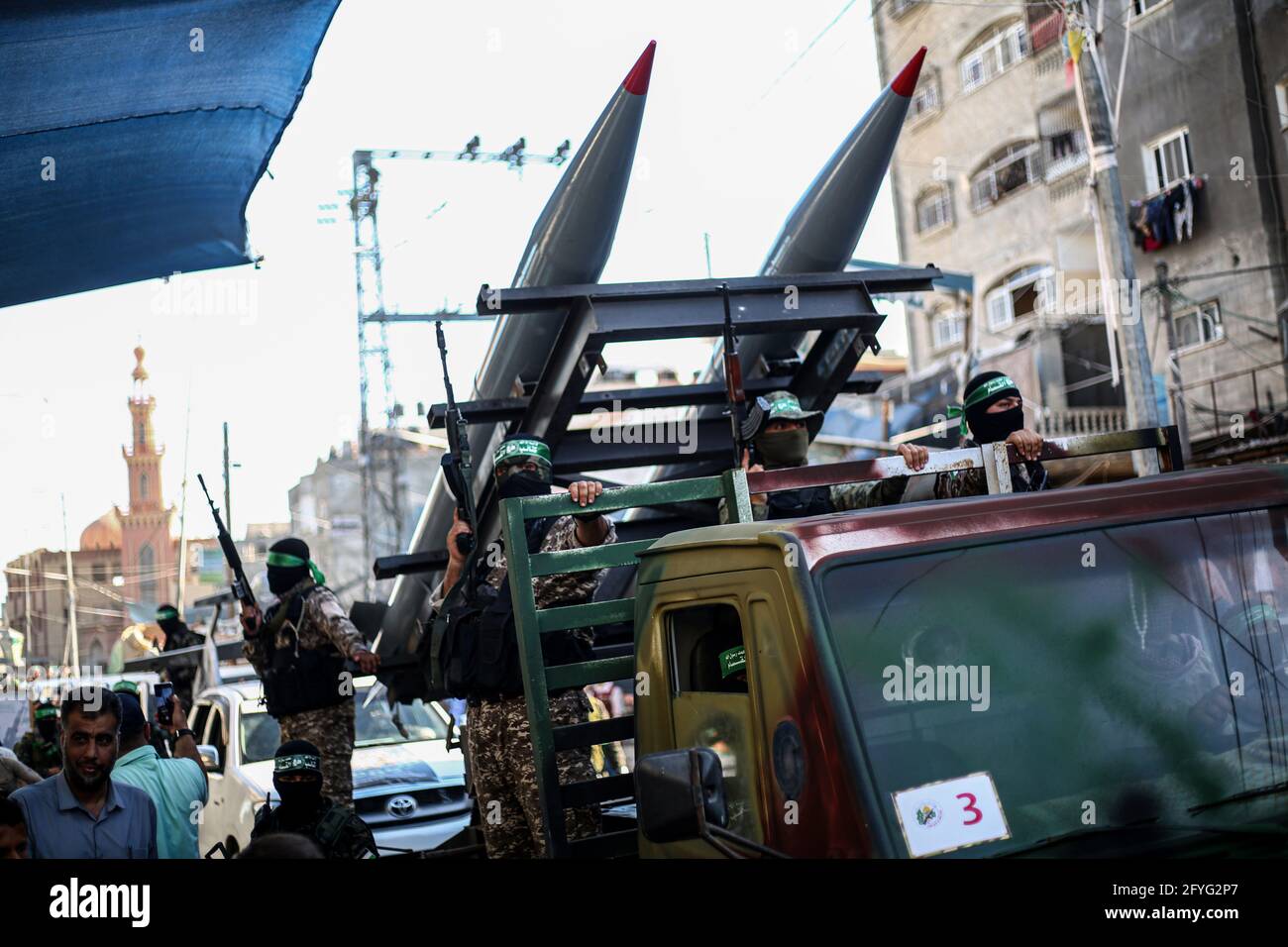 Gaza, Palestina. 27 maggio 2021. I membri mascherati delle Brigate di Izz al-DIN al-Qassam, l'ala militare di Hamas mostrano missili a lungo raggio durante una parata militare sulle strade di Khan Yunis, nella striscia di Gaza meridionale. Credit: SOPA Images Limited/Alamy Live News Foto Stock