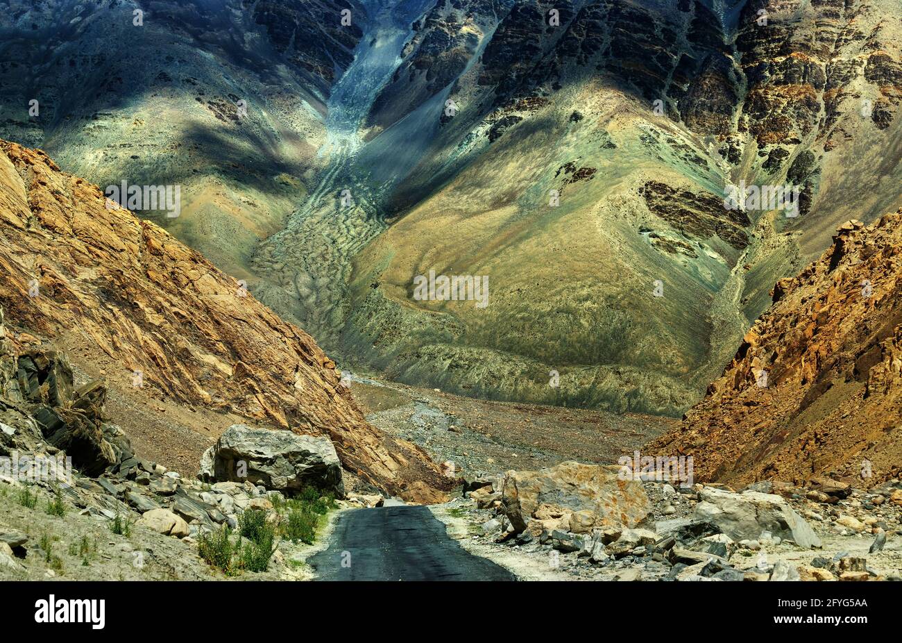 Una strada concreta verso splendide montagne rocciose e vette innevate di Himalaya, Leh, Ladakh, Jammu e Kashmir, India, paesaggio, naturale, scena, viaggio Foto Stock