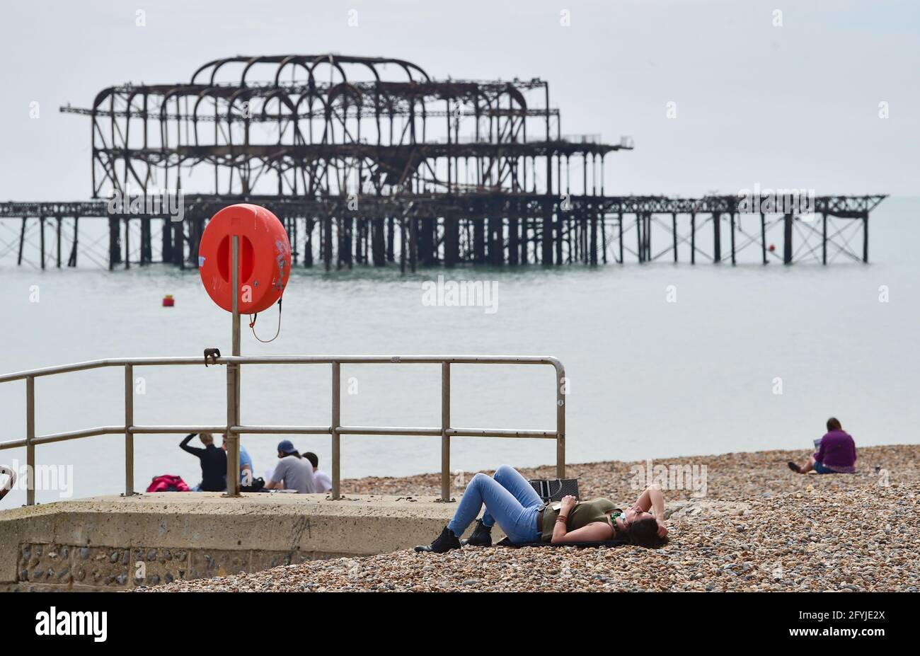 Brighton UK 28 maggio 2021 - i visitatori godono di una calda giornata sulla spiaggia di Brighton mentre la gente comincia ad arrivare per il week-end Bank Holiday con previsioni meteo più calde e soleggiate i prossimi giorni nel Regno Unito con temperature che si prevede raggiungeranno oltre 20 gradi nel Sud-Est : Credit Simon Dack / Alamy Live News Foto Stock