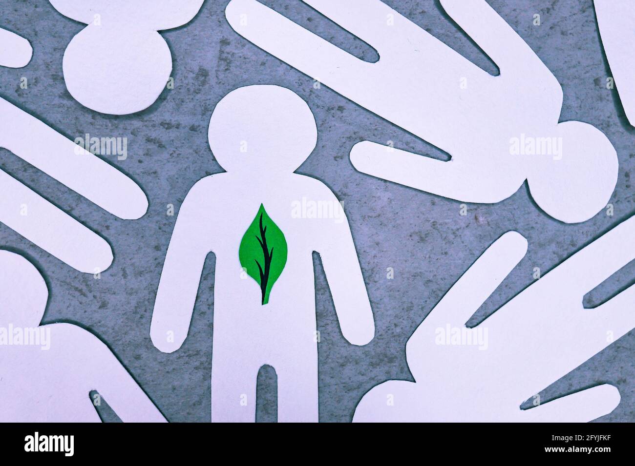 Figure bianche tagliate su carta delle persone. Al posto del cuore, la persona ha foglia verde di albero. Simbolo di persona che si preoccupa per l'ambiente, ama la natura ed è Foto Stock
