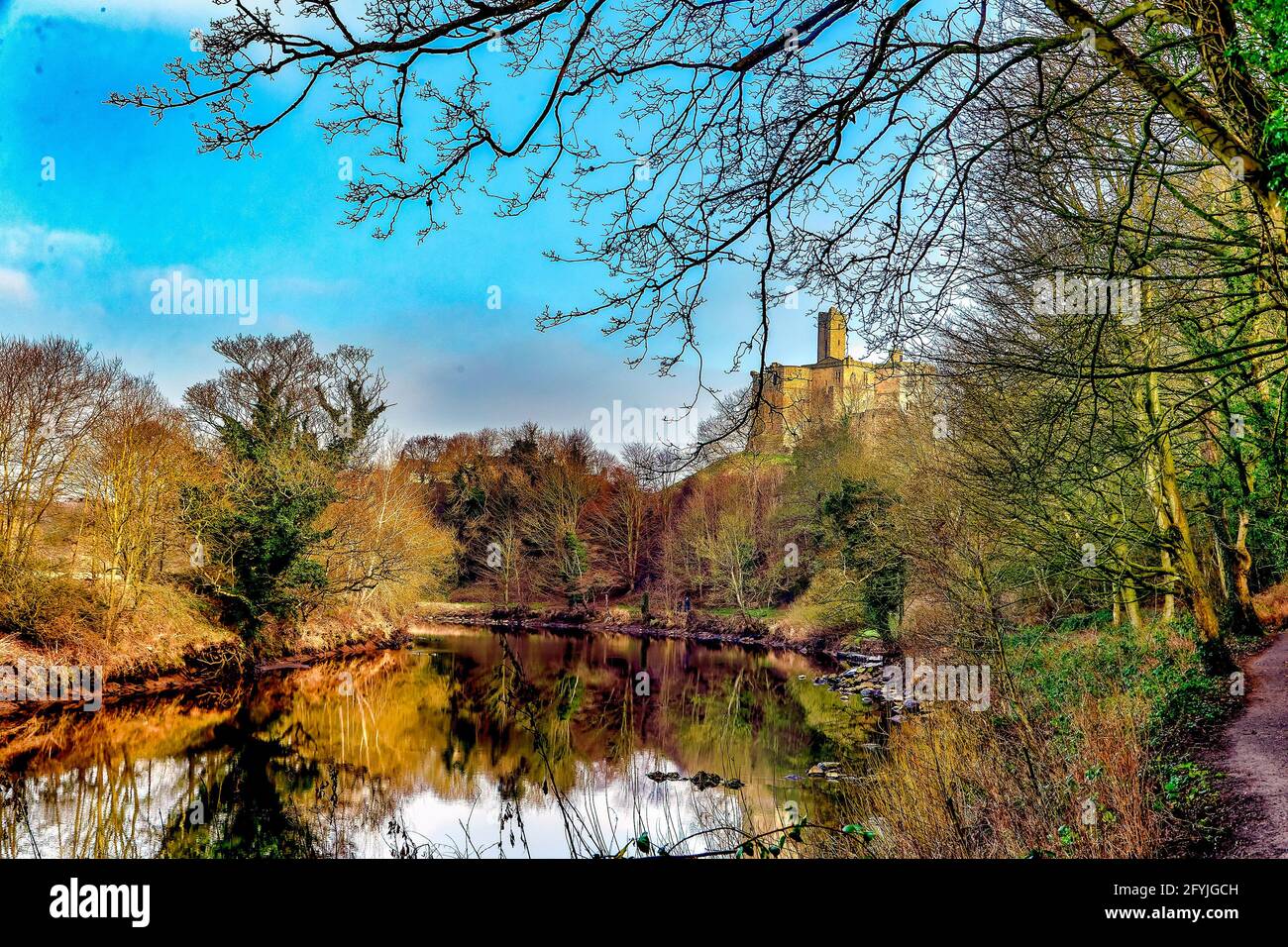 Il castello di Warkworth, Northumberland, si erge sopra il fiume Coquet. Foto Stock