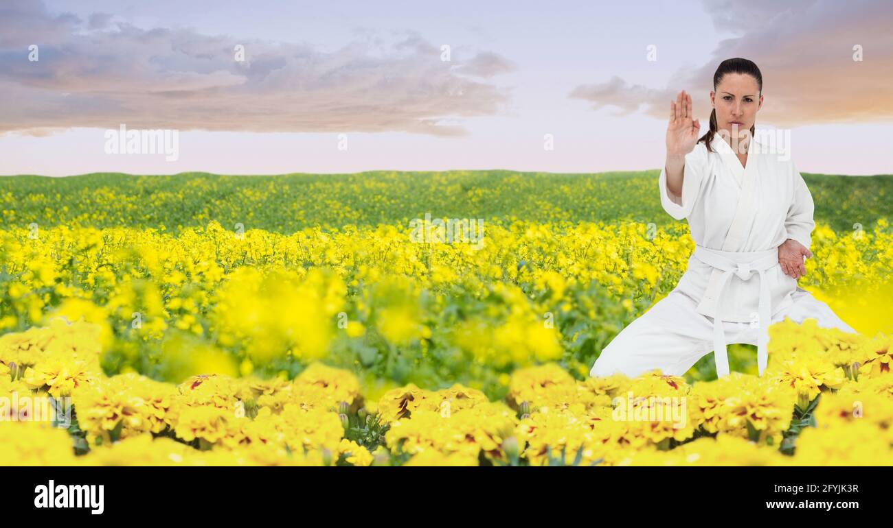 Composizione di artista di Karate marziale femminile con cintura bianca che pratica in campagna Foto Stock