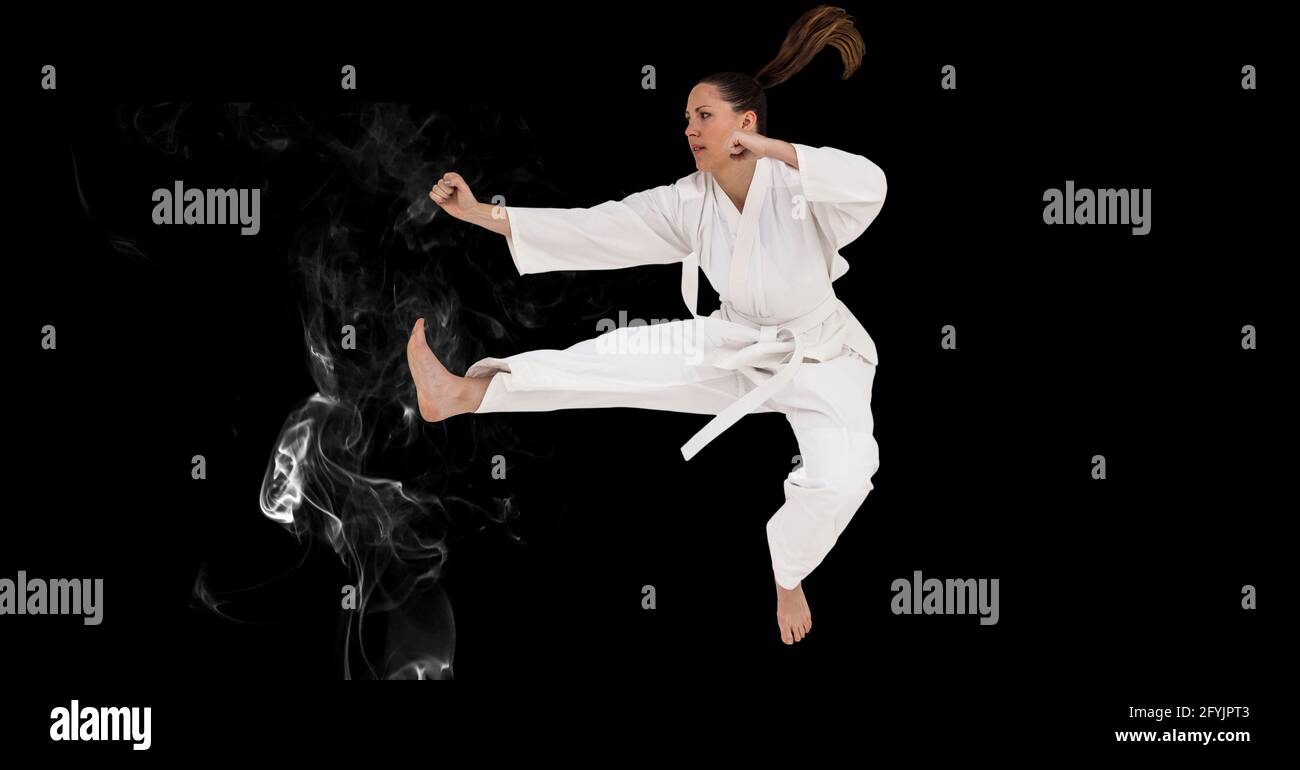 Composizione di artista di Karate marziale femminile con cintura bianca in l'aria sopra fumo e spazio di copia Foto Stock