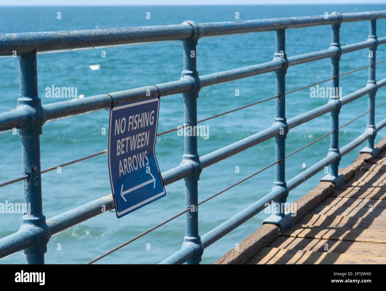 Un cartello indica che non c'è pesca tra le frecce sul molo di Santa Monica, Santa Monica, California, USA Foto Stock