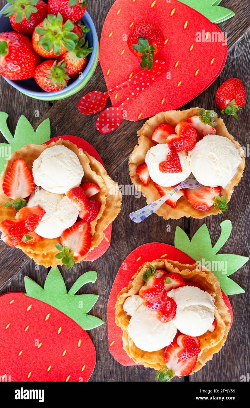 Gelato alla vaniglia con fragole fresche in tazze di waffle Foto Stock