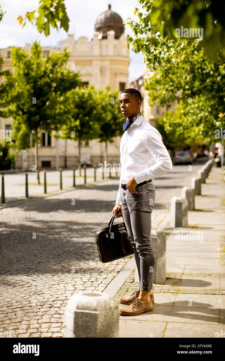 Bell'uomo d'affari afro-americano che ha in attesa di un taxi su un via Foto Stock