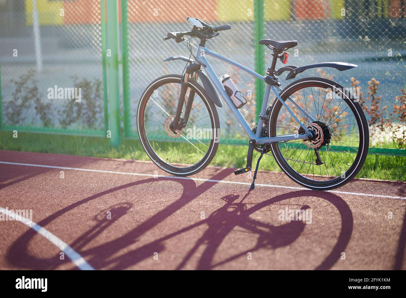 Bicicletta blu con accessori stand sul parco giochi sotto la luce del sole Foto Stock