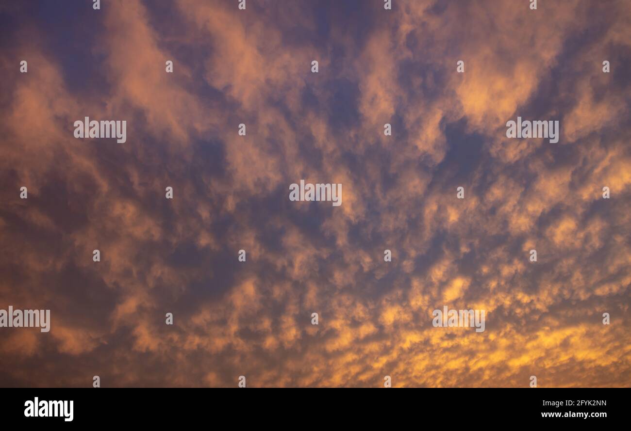 Un concetto di cielo nuvoloso ardente. Raggi solari attraverso pesante blu scuro nero grigio arancio giallo cielo ventoso nuvoloso sfondo, spazio. Drammatico scen astratto Foto Stock