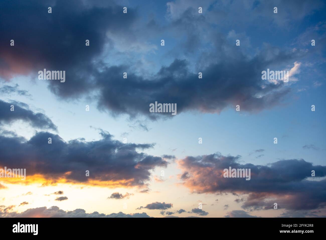Concetto di tramonto su cielo nuvoloso. Sunrise blu grigio arancio giallo colore cielo, raggi del sole attraverso nuvole pesanti come sfondo, spazio. Drammatico scen astratto Foto Stock