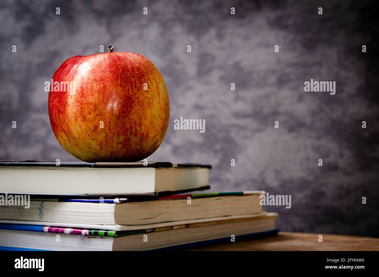 Apple rossa in cima ai libri in aula Foto Stock