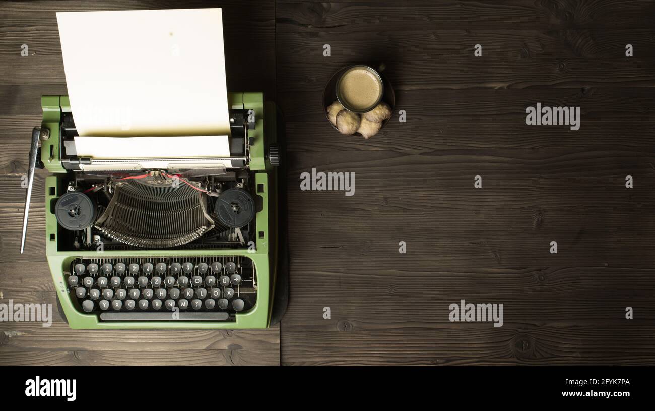 vecchia macchina da scrivere con carta bianca e caffè Foto Stock
