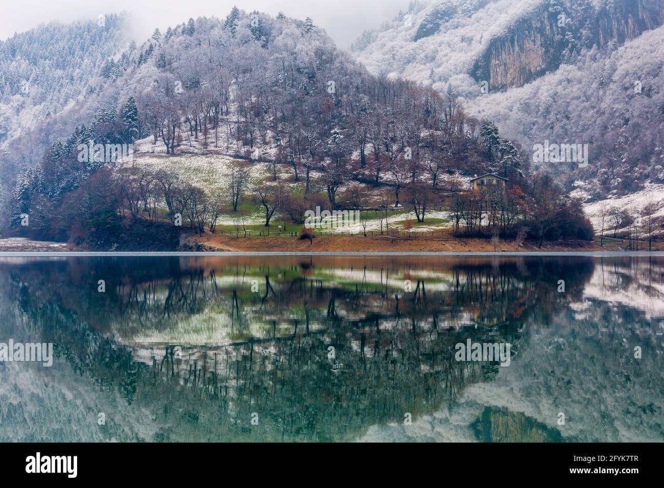 Riflessioni sul lago di montagna del Lago di Tenno, in una fredda giornata nei laghi italiani. Foto Stock