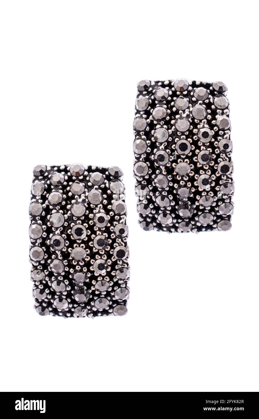 Orecchini neri intarsiati con pietre preziose su sfondo bianco Foto Stock