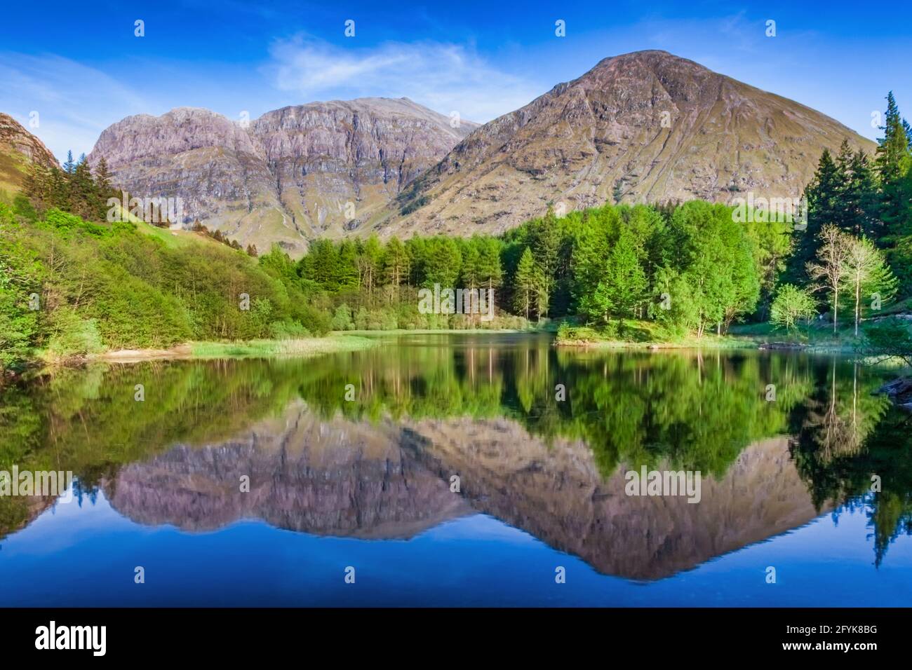 Riflessioni a Torren Lochan in una mattina di primavera ancora a Glencoe, Highlands scozzesi. Foto Stock