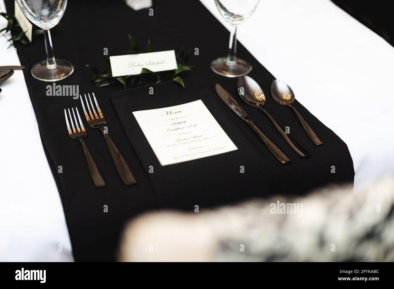 Ambiente personale per cene sociali in bianco e nero, forchette, cucchiai, coltello e menu Foto Stock