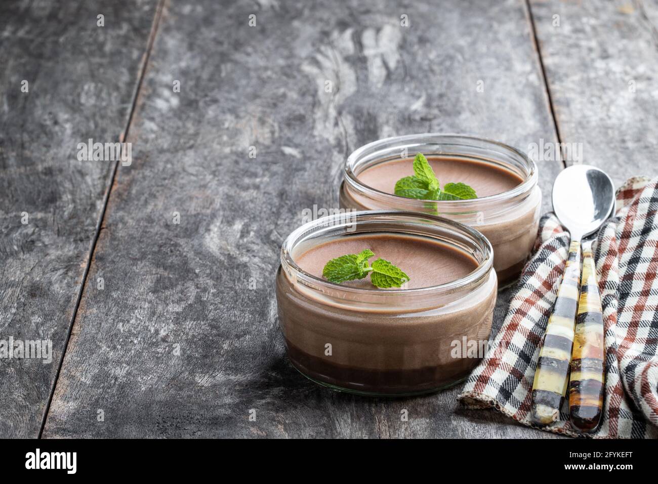 Mini cheesecake vanila in pentole di vetro su legno rustico tabella Foto Stock