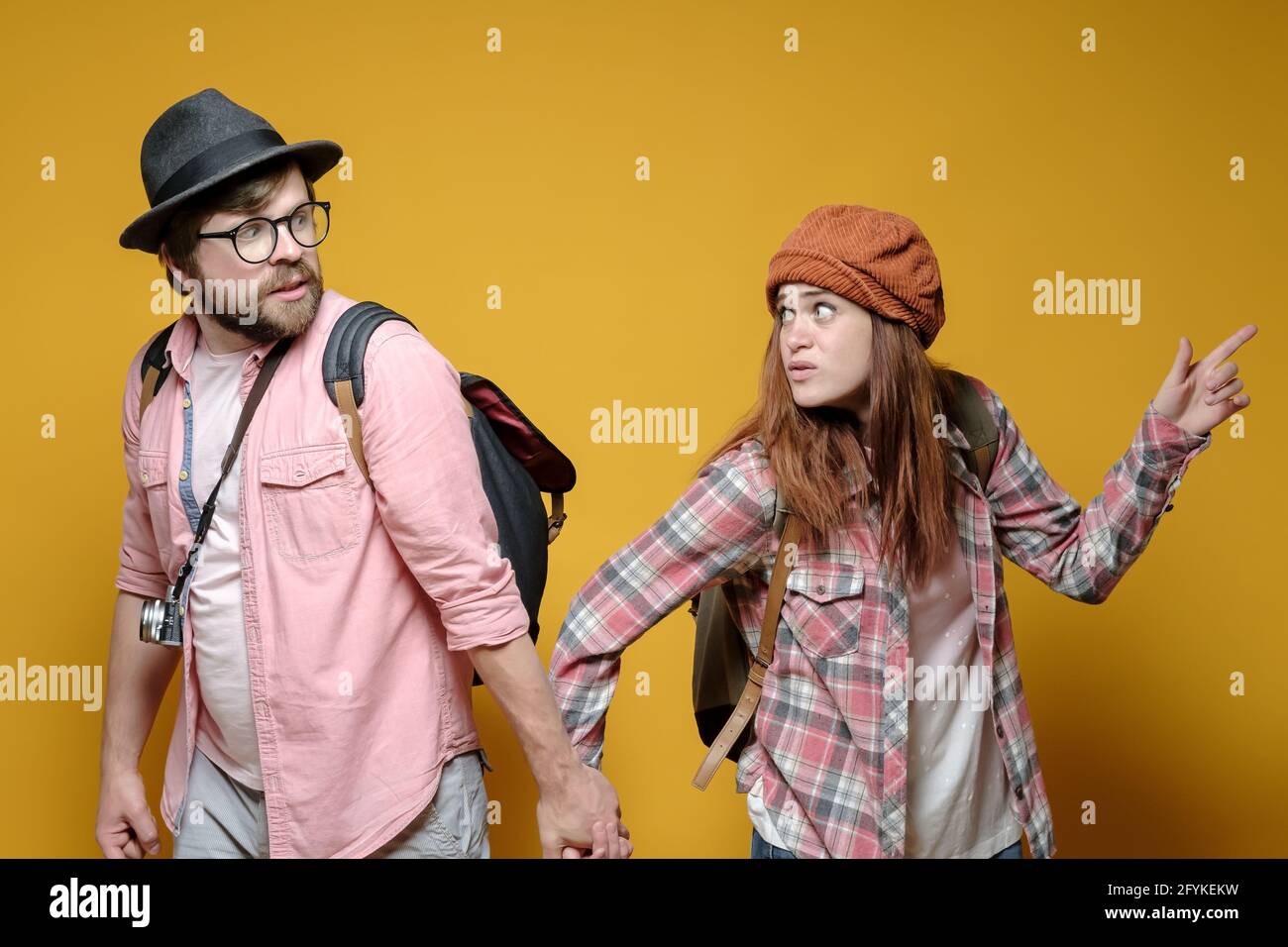 Due turisti non possono decidere dove andare, la donna punta il dito in una direzione, e l'uomo la conduce all'altra. Foto Stock