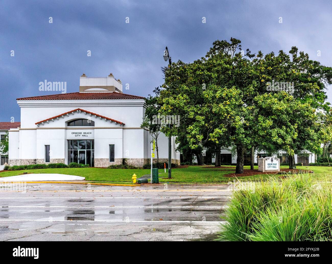 City Hall in Ormond Beach, FL. Dopo una doccia a pioggia con strade bagnate e la riflessione edificio. Foto Stock