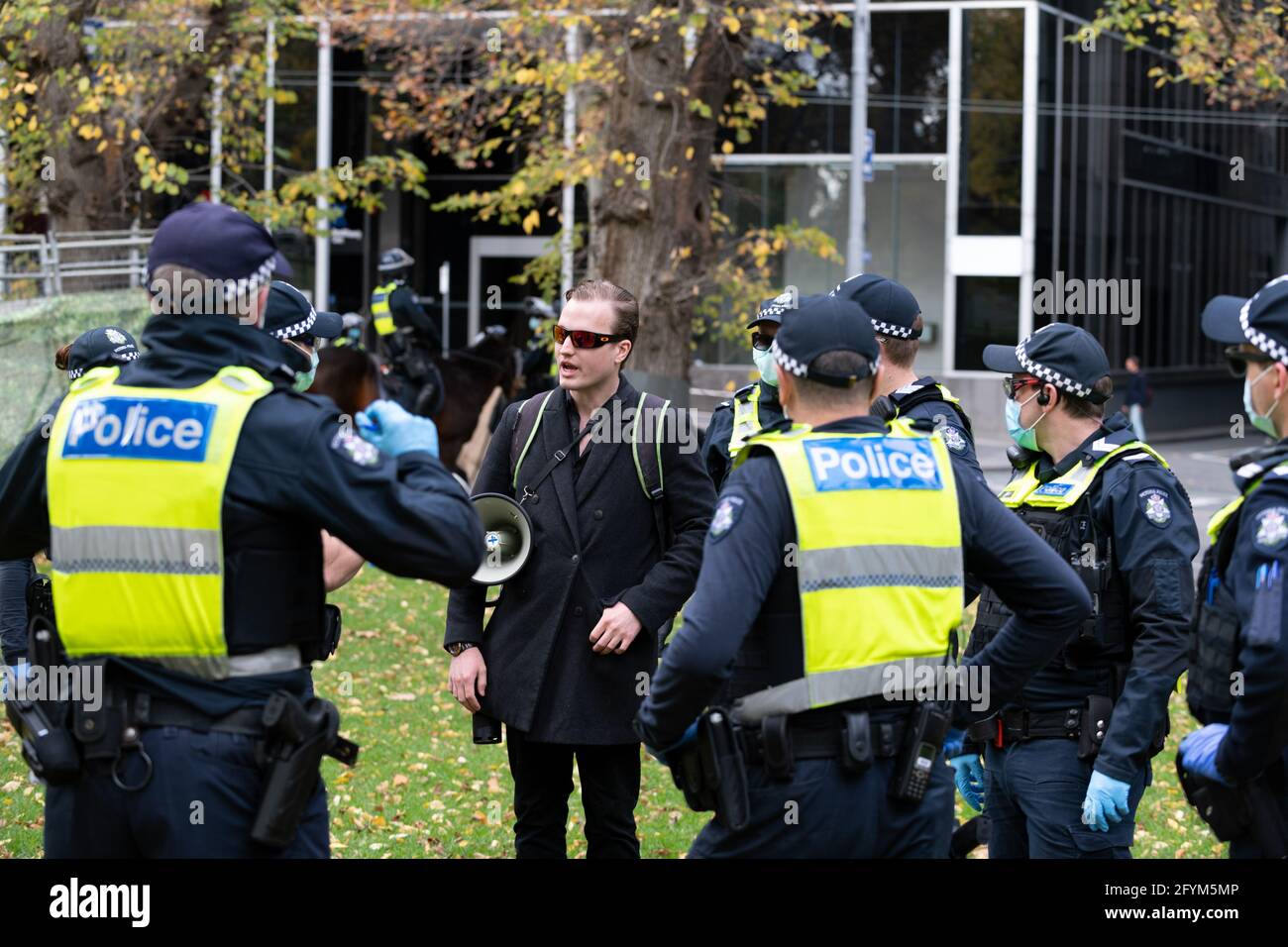 Melbourne, Australia 29 maggio 2021, UN leader di protesta 'Harrison' è scortato dalla polizia durante un raduno programmato 'Millions March' ai Flagstaff Gardens, che era stato annullato dagli organizzatori a causa del blocco snap. I manifestanti più accaniti anti-blocco e anti-vaccinazione frequentano ancora il parco e si sono alleati contro il governo. Credit: Michael Currie/Alamy Live News Foto Stock