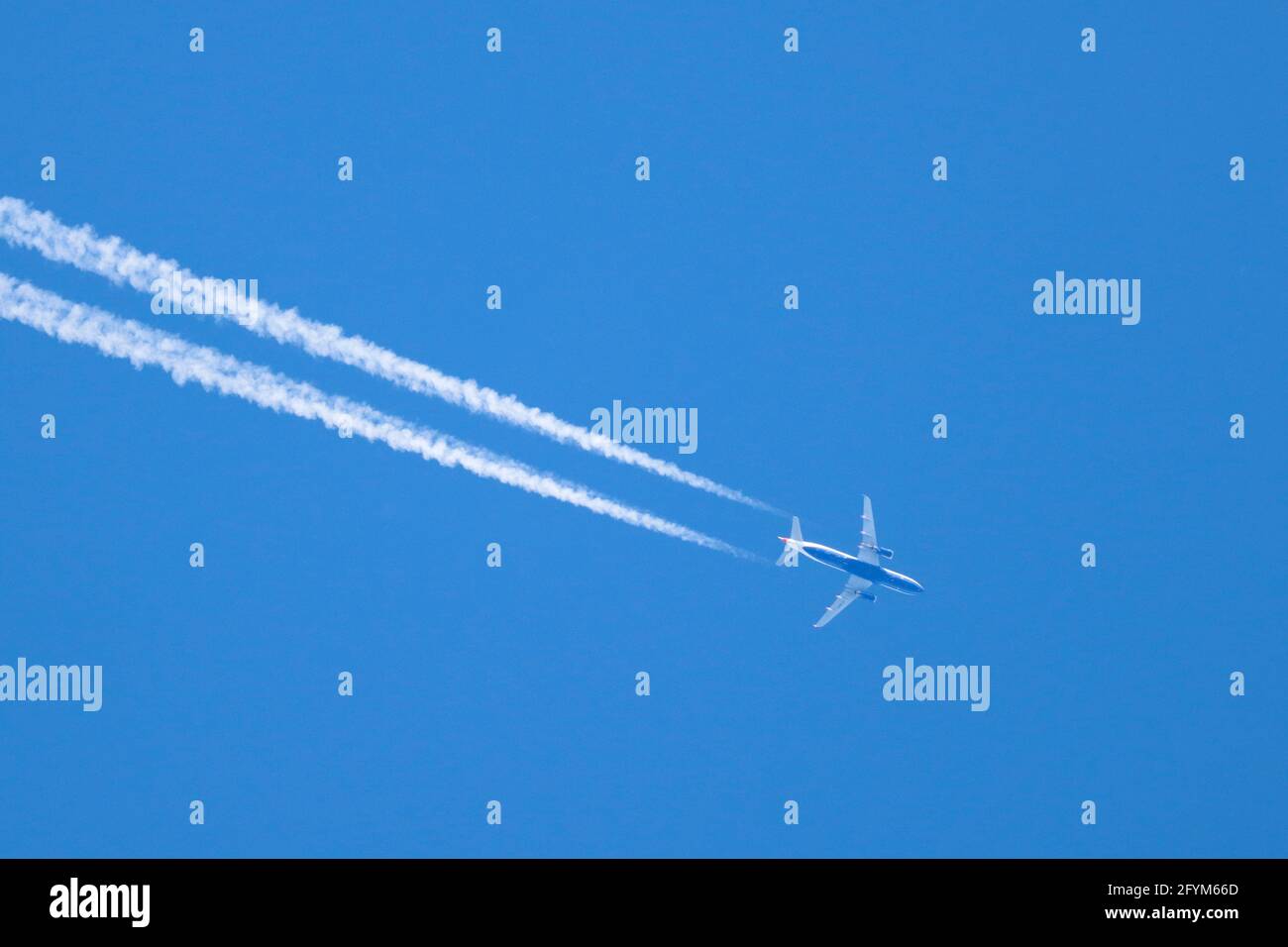 AALEN, GERMANIA - 26 maggio 2021: Un aereo da passanger sta volando attraverso un cielo blu senza nuvole. Lascia tracce di condenstation bianche w Foto Stock