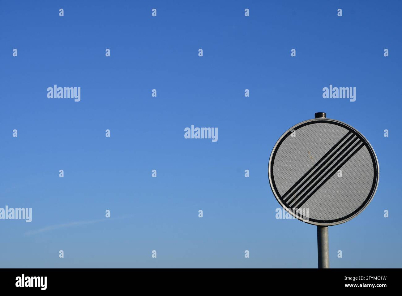 segnale stradale circolare tedesco che abroga qualsiasi limite di velocità  di fronte al cielo blu Foto stock - Alamy