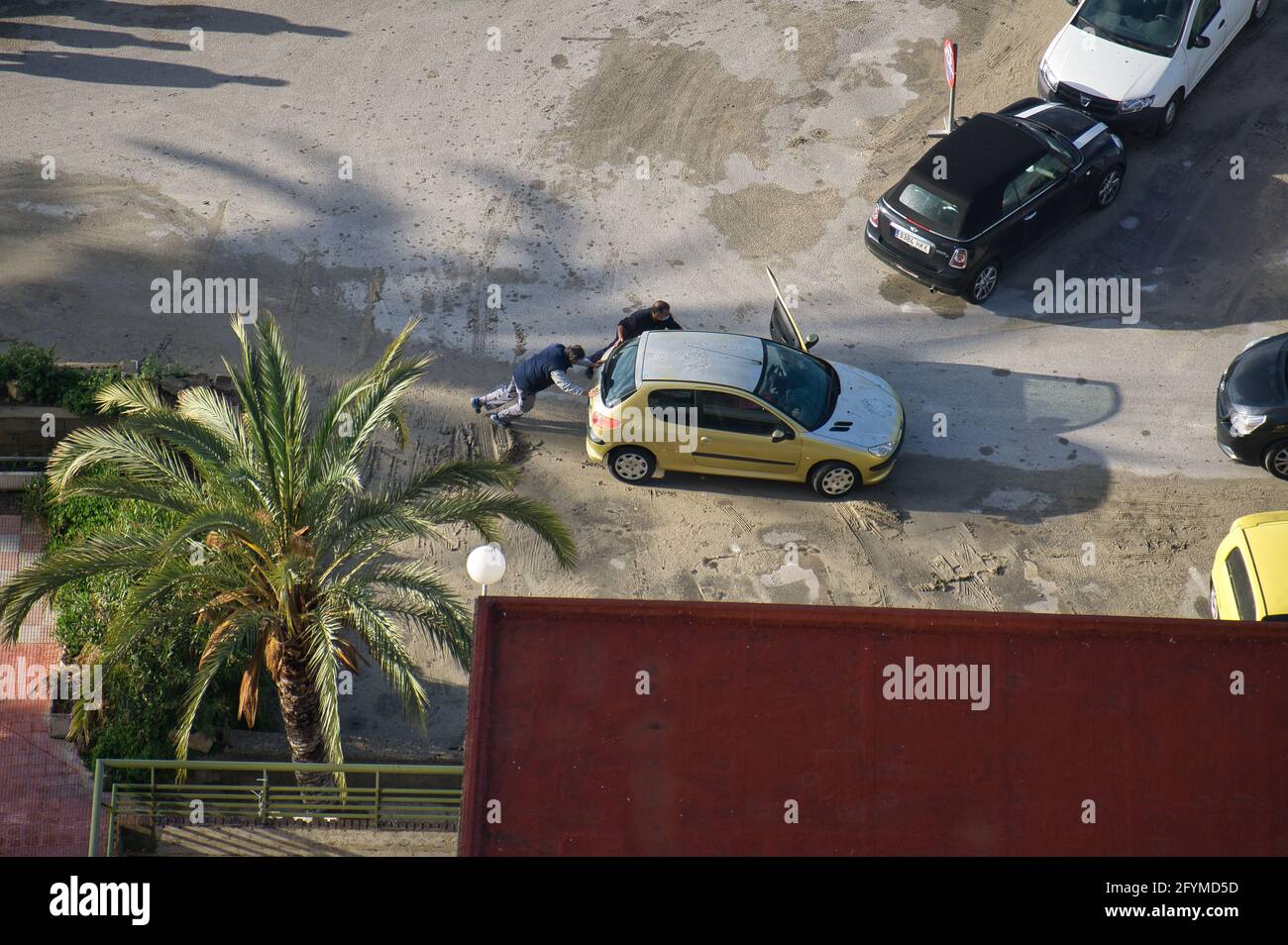 ALICANTE, SPAGNA, APRILE 28 2021: Due uomini che spingono auto danneggiata nella città di Alicante, nella Comunità Valenciana, Spagna. Vista Foto Stock