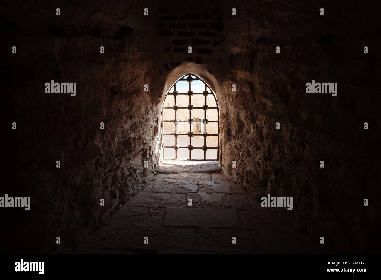 Finestra con bar nella vecchia fortezza, sfondo architettonico scuro Foto Stock