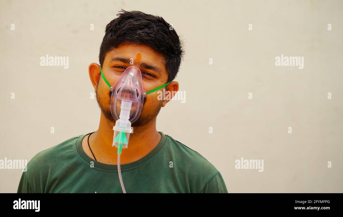 Jaipur, India - 21 maggio: Primo piano ragazzo Yong malato con maschera di ossigeno viso con flusso di ossigeno liquido all'esterno dell'ospedale. Ragazzo infettato con la malattia di Covid 19. Foto Stock