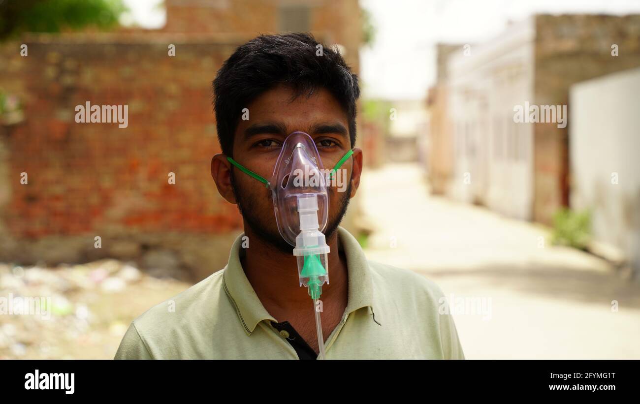 Jaipur, India - 21 maggio: Primo piano ragazzo Yong malato con maschera di ossigeno viso con flusso di ossigeno liquido all'esterno dell'ospedale. Ragazzo infettato con la malattia di Covid 19. Foto Stock