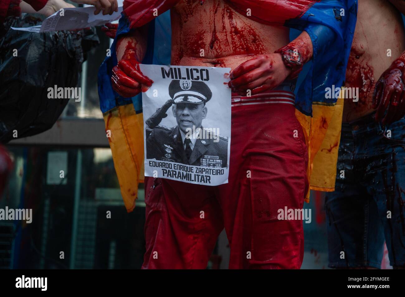 Bogotà, Colombia. 28 maggio 2021. Un dimostratore che agisce su una performance contiene una foto del generale Zapaterio, comandante dell'esercito colombiano come migliaia si sono riuniti per protestare contro il presidente della Colombia Ivan Duque Maraquez e contro i casi di disordini e brutalità della polizia che avevano lasciato almeno 45 morti durante il primo mese di manifestazioni, a Bogotà, Colombia, il 28 maggio 2021. Credit: Long Visual Press/Alamy Live News Foto Stock