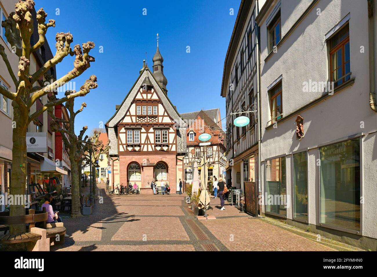 Hofheim, Germania - Marzo 2021: Strada con tradizionali edifici a graticcio nel centro storico della città vecchia di Hofheim piena di persone in giornata di sole Foto Stock