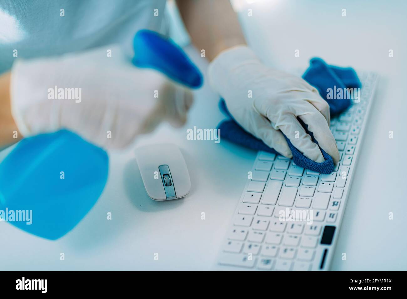 Disinfezione della tastiera e del mouse del computer con alcool Foto Stock