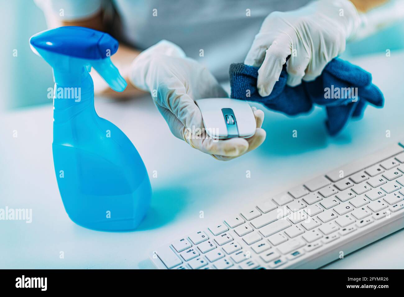 Disinfezione della tastiera e del mouse del computer con alcool Foto Stock