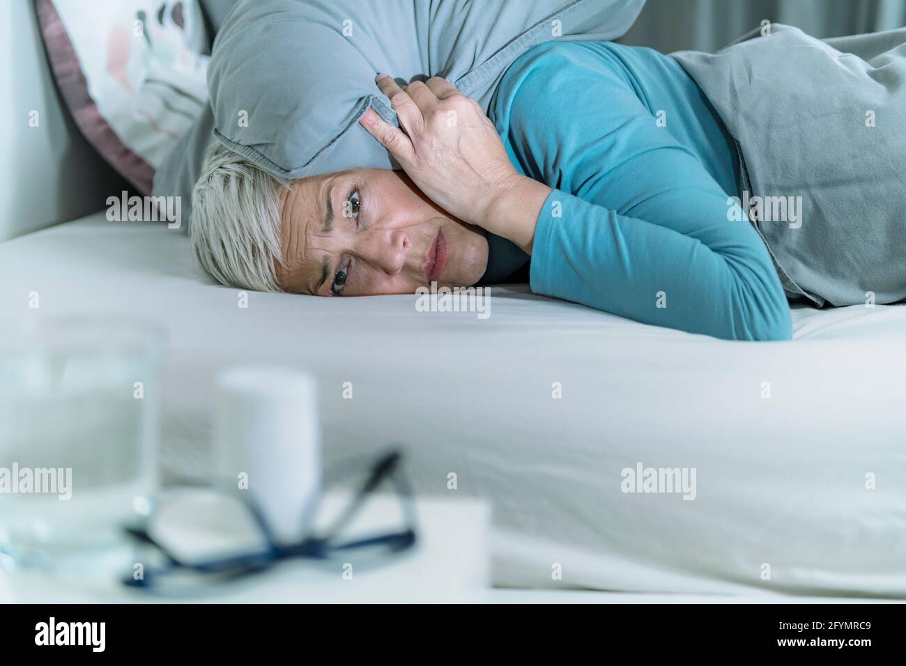 La donna si sveglia con il rumore Foto Stock