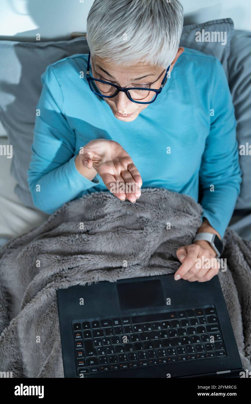Donna matura che effettua una videochiamata sul suo laptop Foto Stock