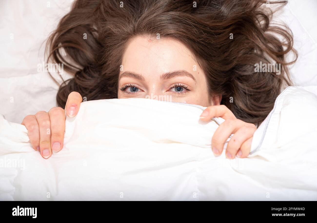 La donna che si nasconde sotto coperta Foto Stock
