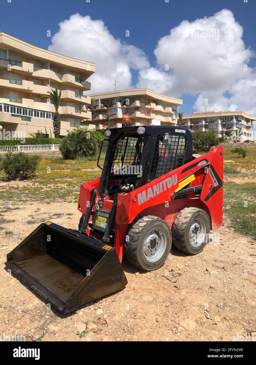 Alicante, Spagna - Maggio, 2021: Mini caricatore compatto rosso per utenze lasciato all'aperto. Foto di alta qualità Foto Stock