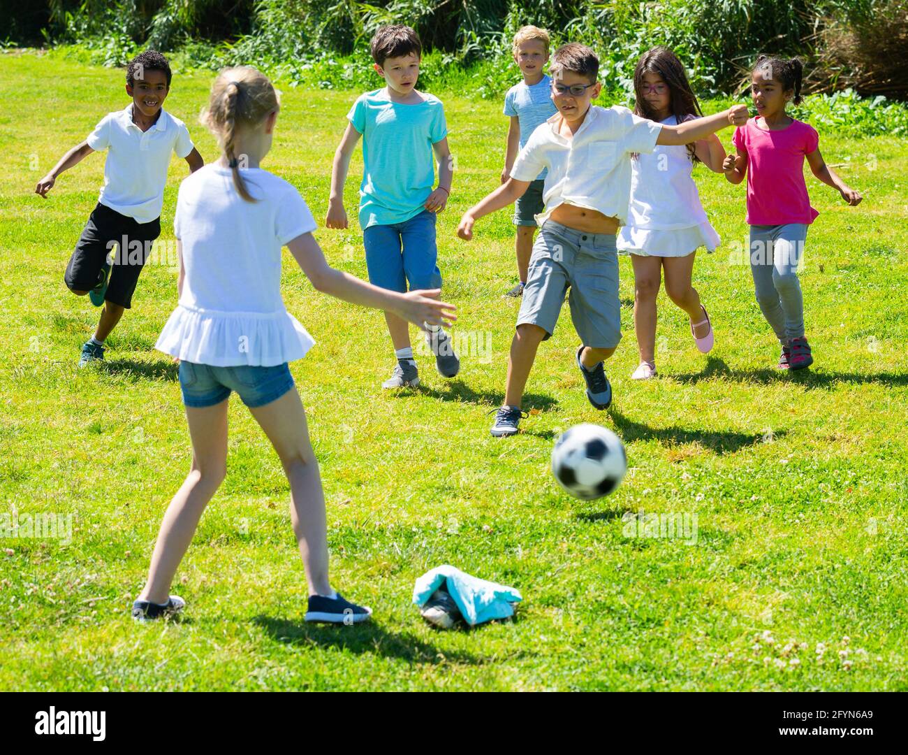 Società di felici i bambini a giocare a calcio nel parco giochi nel parco  Foto stock - Alamy